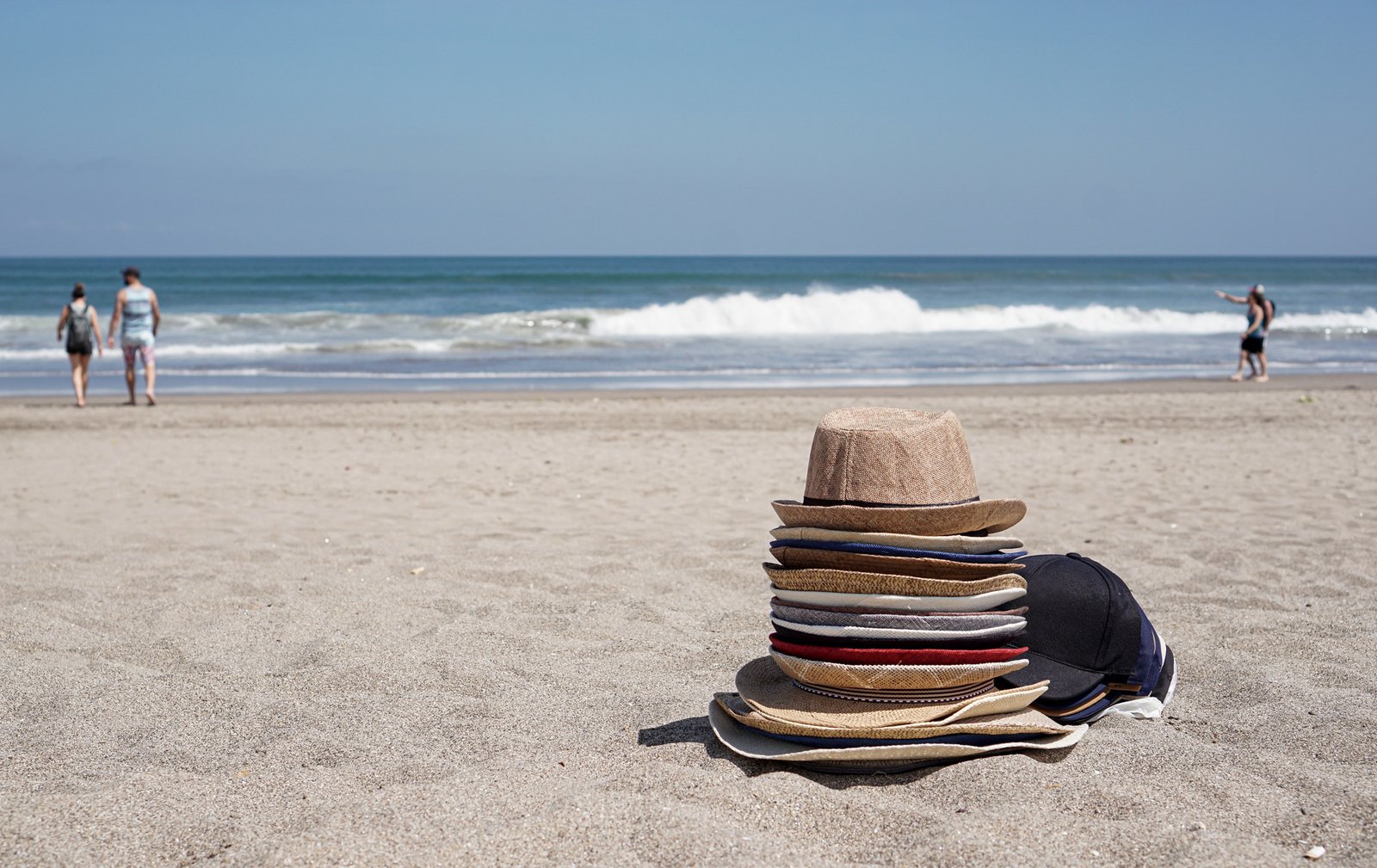 pile of hats by the Bali beach on a sunny day.