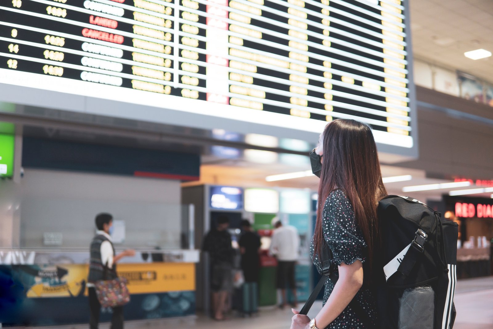 Travel women standing and during check flight schedule on screen for traveling